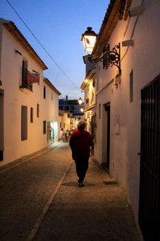 Altea, Alicante, Spain- June 12, 2021: People going shopping, walking and relaxing at night through the Narrow streets of Altea village, Alicante, Spain
