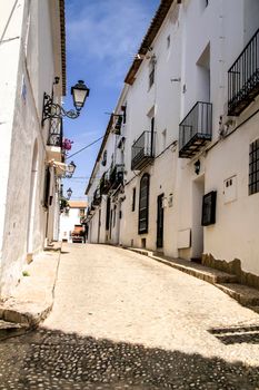 Altea, Alicante, Spain- June 12, 2021: Narrow streets and typical whitewashed facades in Altea village, Alicante, Spain