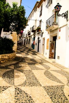 Altea, Alicante, Spain- June 12, 2021: Narrow streets and typical whitewashed facades in Altea village, Alicante, Spain