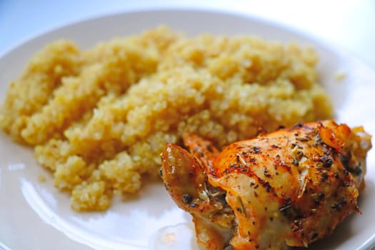 A piece of baked chicken with porridge on a light plate. A light and healthy lunch. Healthy eating