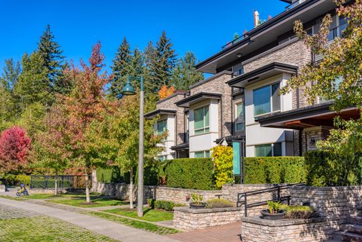 Paved pathway along the row of residential townhouses on autumn day