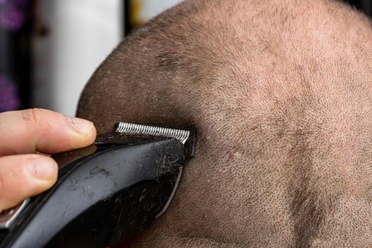 Man shaving or trimming his hair using a hair clipper