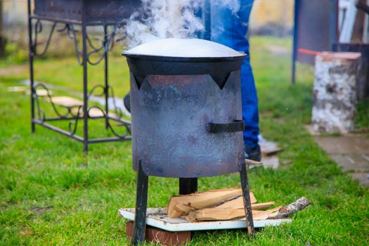 Cooking in a cauldron on the fire. Picnic outdoors in summer. Close-up