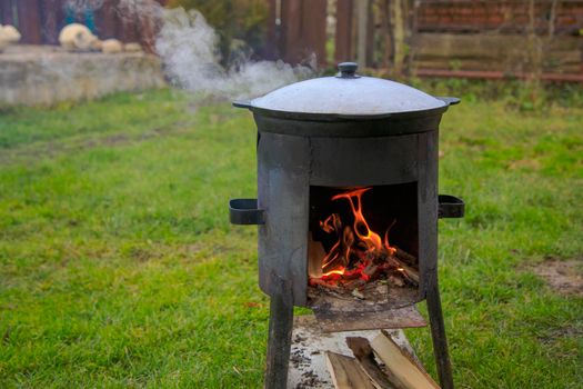 Cooking in a cauldron on the fire. Picnic outdoors in summer. Close-up