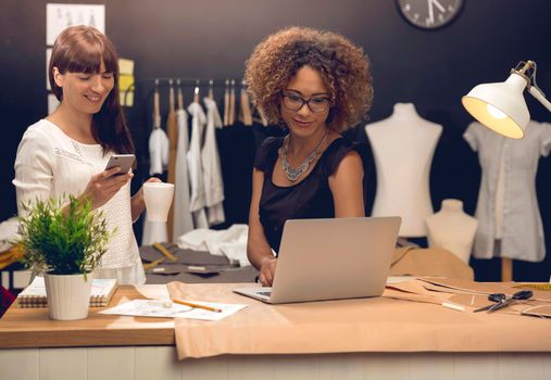 Two young entrepreneur women, and fashion designers working in their atelier