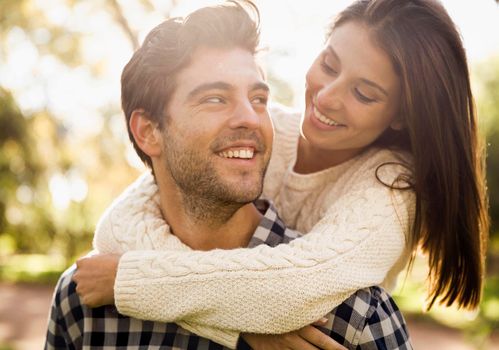 Happy couple in the park looking at each other and laughing