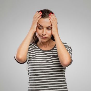 Portrait of a woman with a worried expression, overa gray background