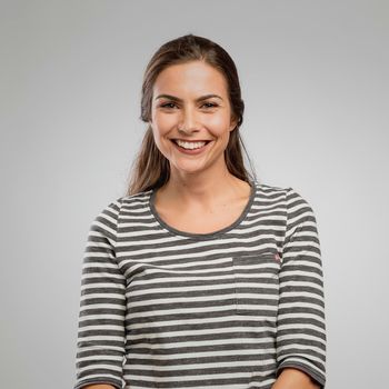 Portrait of a beautiful happy woman smilling over a gray background