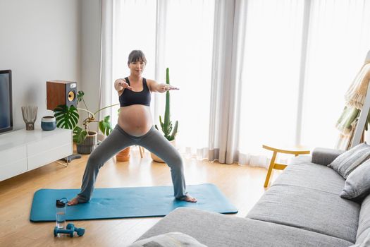 Pregnant woman doing exercises at home