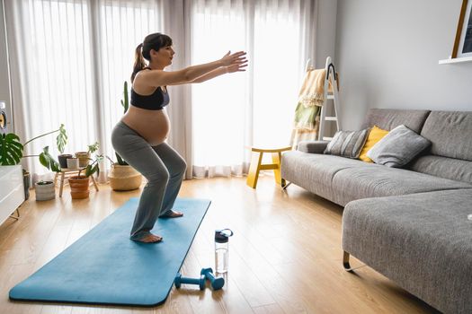 Pregnant woman doing exercises at home