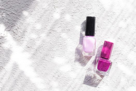 Nail polish on a white background with shadows . The concept of nail polish without inscriptions. Light background and shadows. Copy space . Article about the choice of varnish. Cosmetology