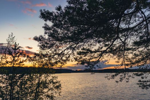 Sunset on a lake with rocky shores in Karelia.