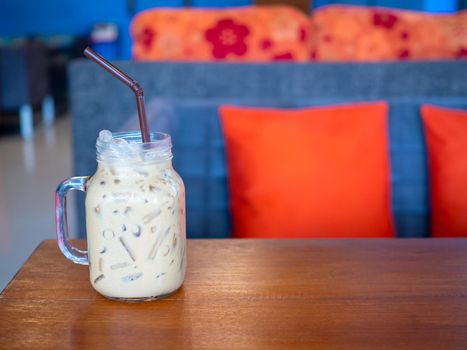 Fresh milk tea in a glass placed on a wooden floor. with free space