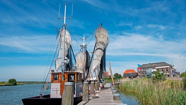 Old traditional fishing ship in the harbor from Workum in the Netherlands