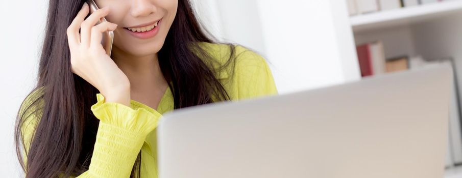 Young asian business woman working form home office and call phone for success at home, businesswoman using laptop computer on desk, female talking smartphone at workplace, communication concept.