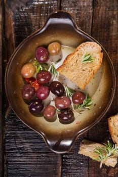 Snack of homemade bread and black olives in brine