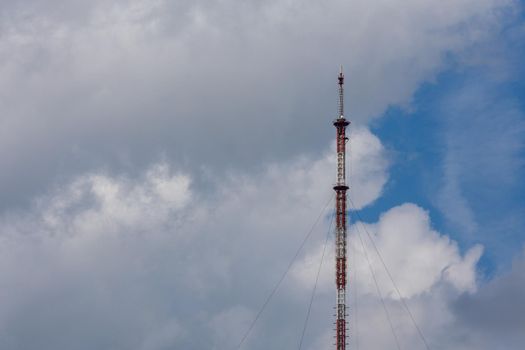 tall metal frame television tower on cloudy sky daylight background.