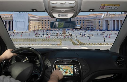 Driving a car while using the touch screen of a GPS navigation system in the scenic St. Peter's Square in Vatican City, Rome, Italy