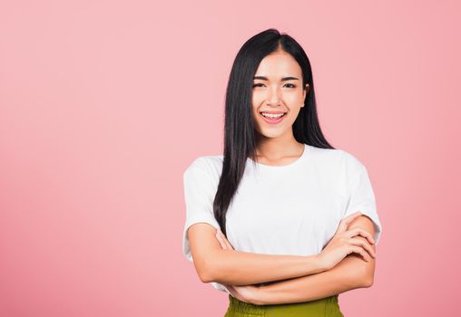 Asian happy portrait beautiful cute young woman standing her smile confidence with crossed arms isolated, studio shot on pink background and copy space, Thai female looking to camera