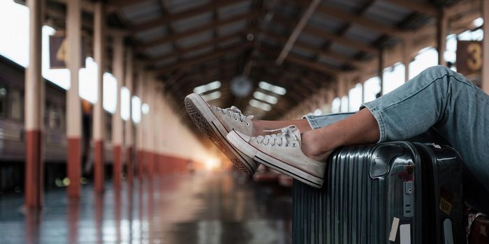 Alone traveler tourist walking with luggage at train station. work and travel lifestyle concept