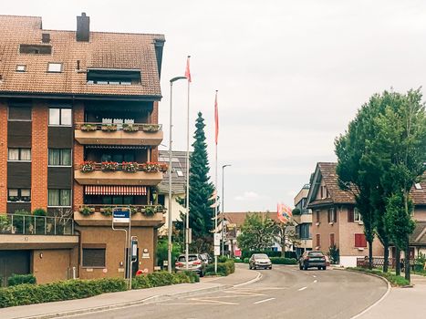 Wollerau, canton of Schwyz, Switzerland circa June 2021: Apartment building and house on street, Swiss architecture and real estate