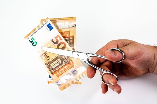 cut 50 euro banknotes with scissors on white background