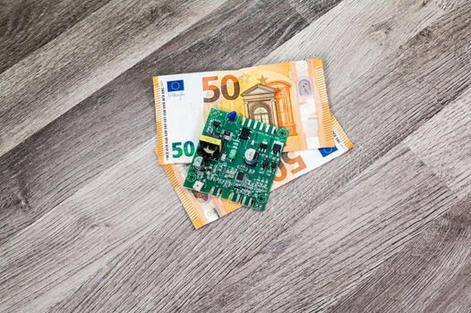 50 euro banknotes and electronic card on wooden table