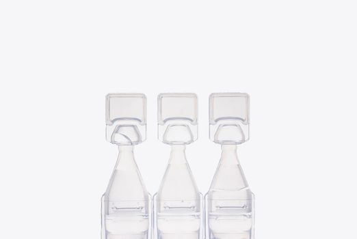 Eye drop bottles on white background. Blank white plastic containers for fluid. Pharmaceutical packaging product.