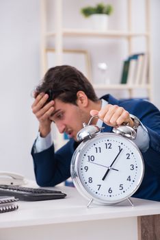 Businessman employee in urgency and deadline concept with alarm clock