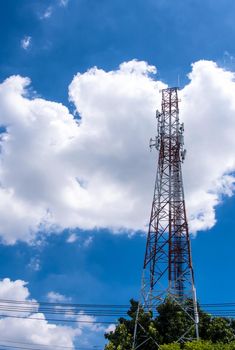 Telecommunication equipment on the high rise steel structure tower and the white clouds in blue sky