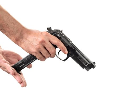 Close-up of a man's hand holding and loaded a magazine in a gun isolated white background.