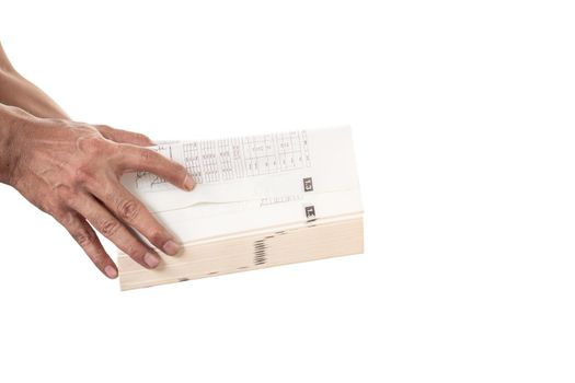Close-up of man's hand holding and opening a thick book on white background.