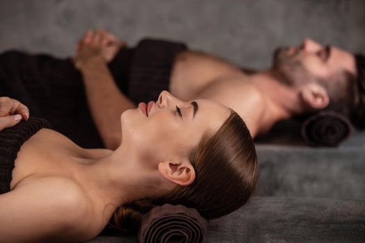 Beautiful couple relaxing together at spa centre at beauty treatment massage