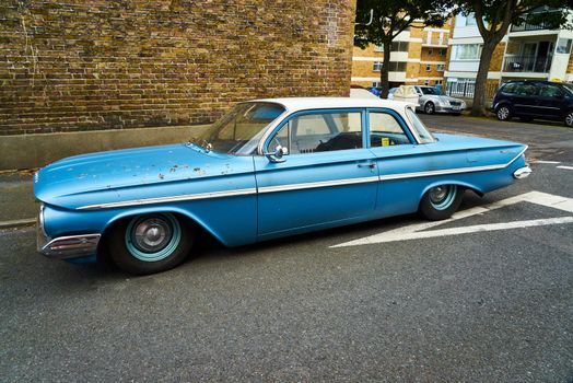 A blue 1961 4 door Chevrolet Bel Air sedan with chrome bumpers