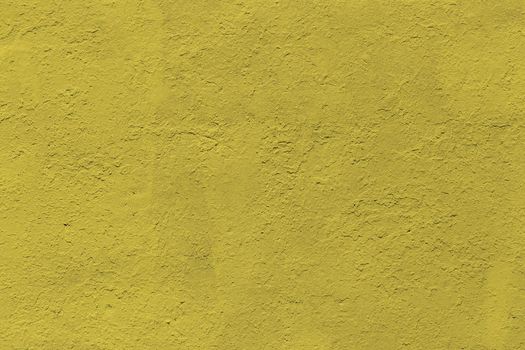 background and texture of flat thick painted matte yellow surface under direct sunlight - new paint over fragments of old peeled one