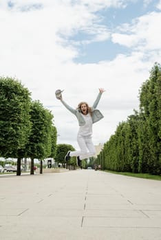 Happy young woman in white t-shirt jumping and screaming in the park. mock up design