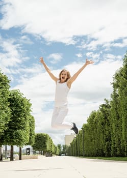 Happy young woman in white t-shirt jumping and screaming in the park. mock up design