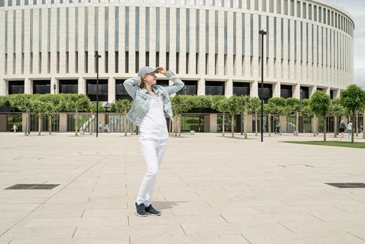 Happy young woman in jeans clothes standing in the park.