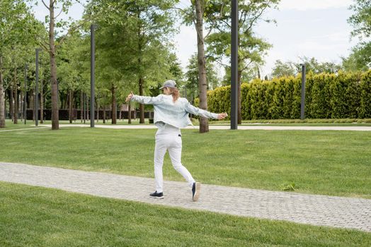 Woman in casual jeans clothes texting on her mobile phone, walking in the park