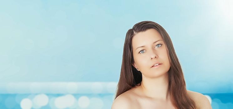 Skincare and sun protection in summer. Portrait of a beautiful young suntanned woman, blue sea and sky on background, beauty, wellness and travel concept.