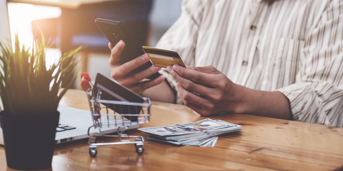 A Man holding credit card and typing in credit card number smartphone for online shopping and payment makes a purchase on the Internet