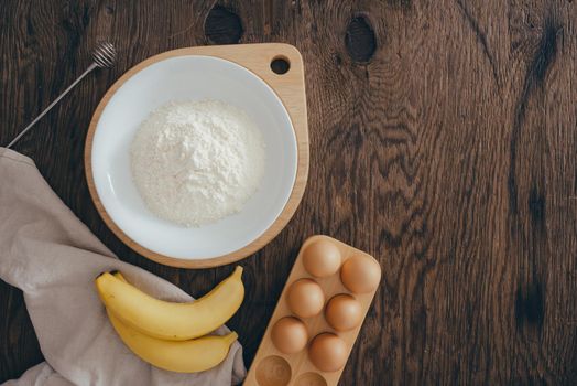 Ingredients for butter cake on wooden table