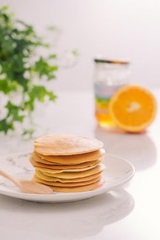Stack of delicious pancakes on plate isolated on white