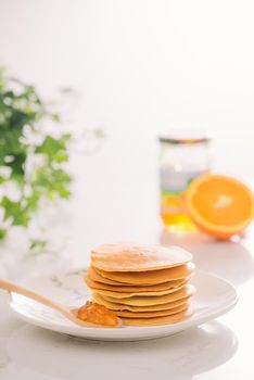 Stack of delicious pancakes on plate isolated on white