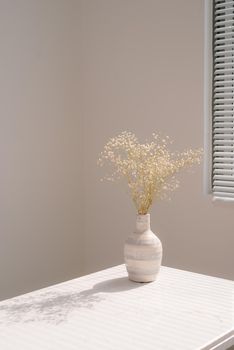 Beautiful spring flowers in vase on window background.