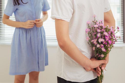 Couple in love. Romantic man giving flowers to his girlfriend