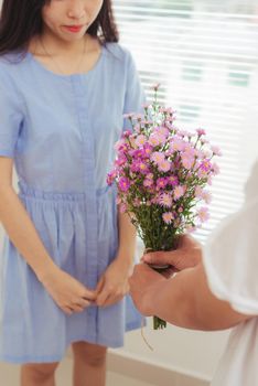 Couple in love. Romantic man giving flowers to his girlfriend