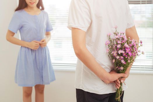 Couple in love. Romantic man giving flowers to his girlfriend