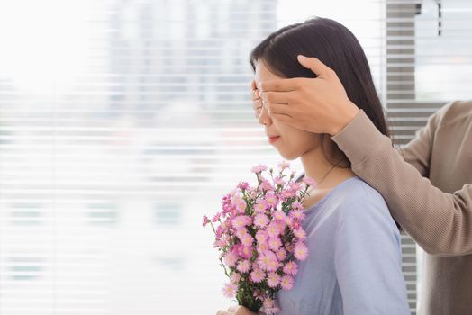 Couple in love. Man is covering his woman eyes making a surprise