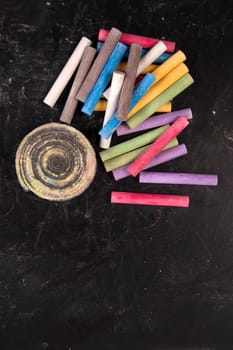 Background of blackboard with pieces of chalk to artistic use